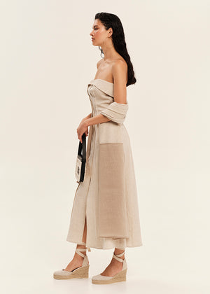 Woman wearing a beige strapless dress with a white background