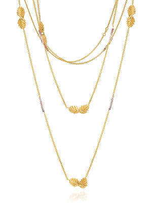 Gold layered necklace on a white background