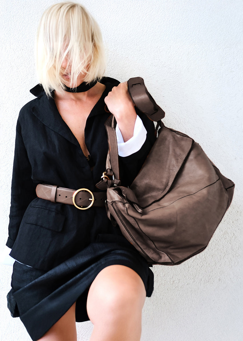 Person holding a brown bag against a white background