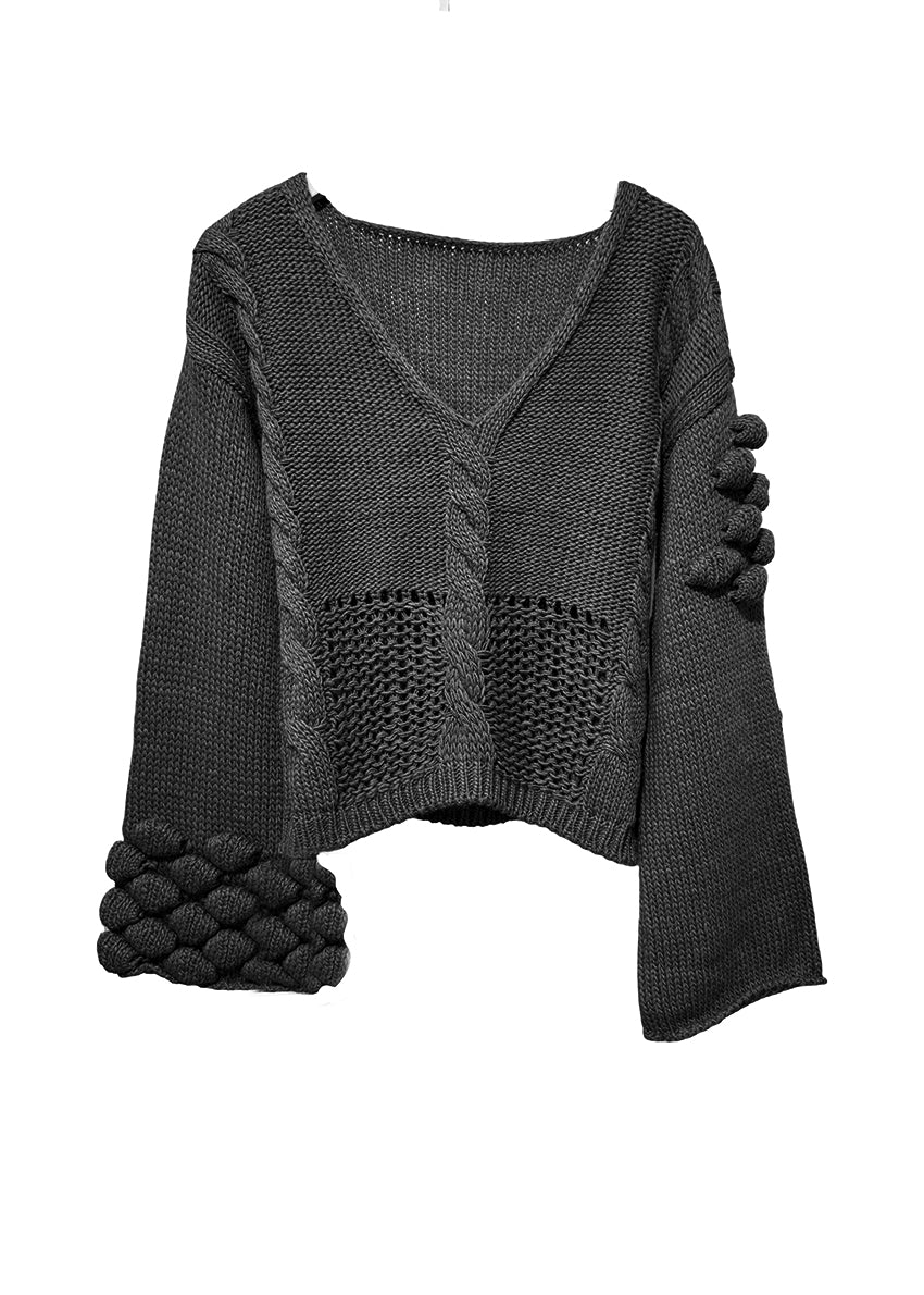 Black gray knitted sweater with textured sleeves on a white background