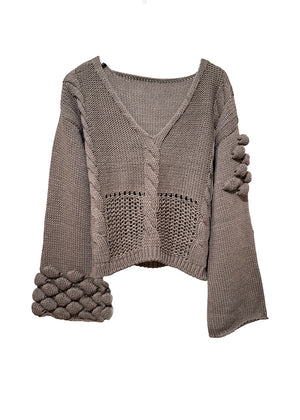 Mocha knitted sweater with textured sleeves on a white background