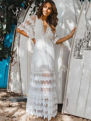 Woman wearing a white lace dress standing outdoors with a natural background