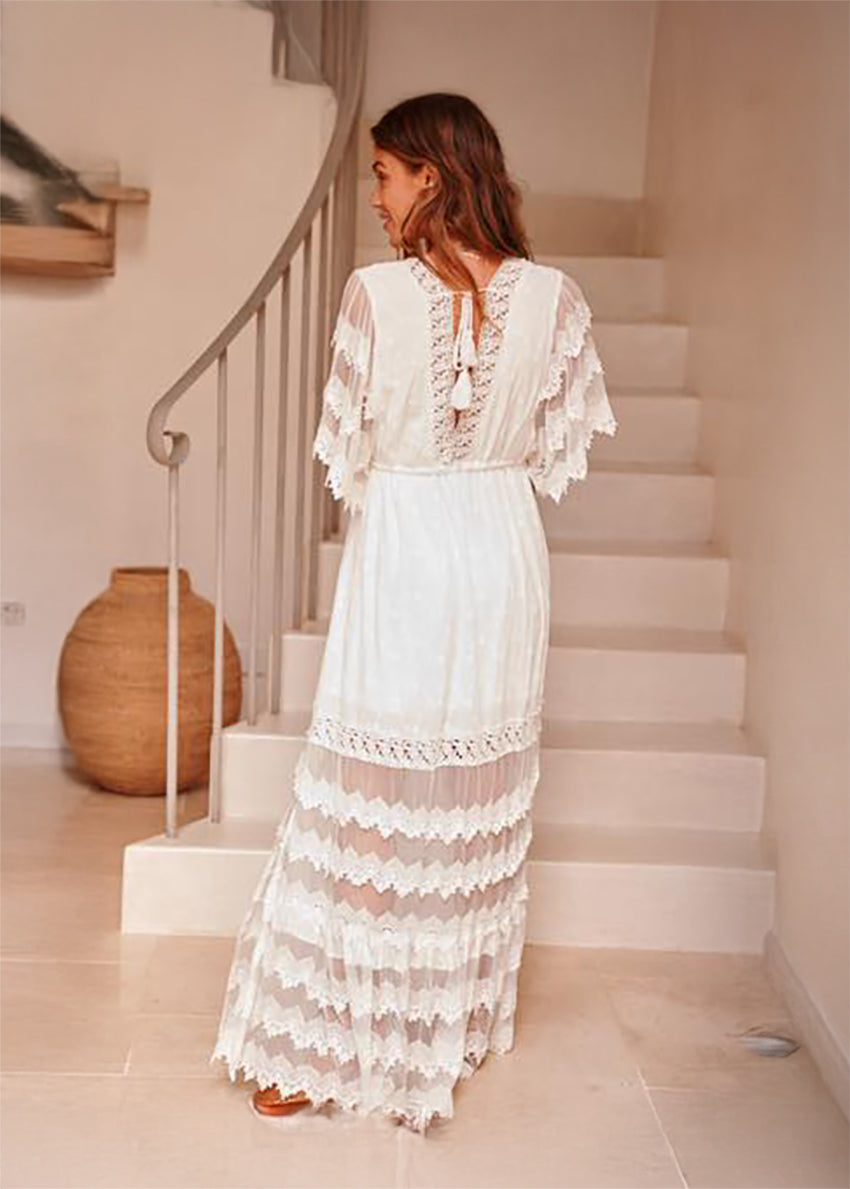 Woman in a white lace dress standing on a staircase in a home setting