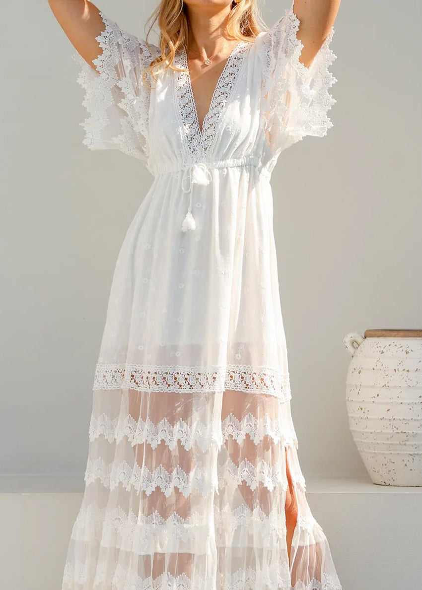 White lace dress worn by a person against a plain background