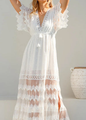 White lace dress worn by a person against a plain background