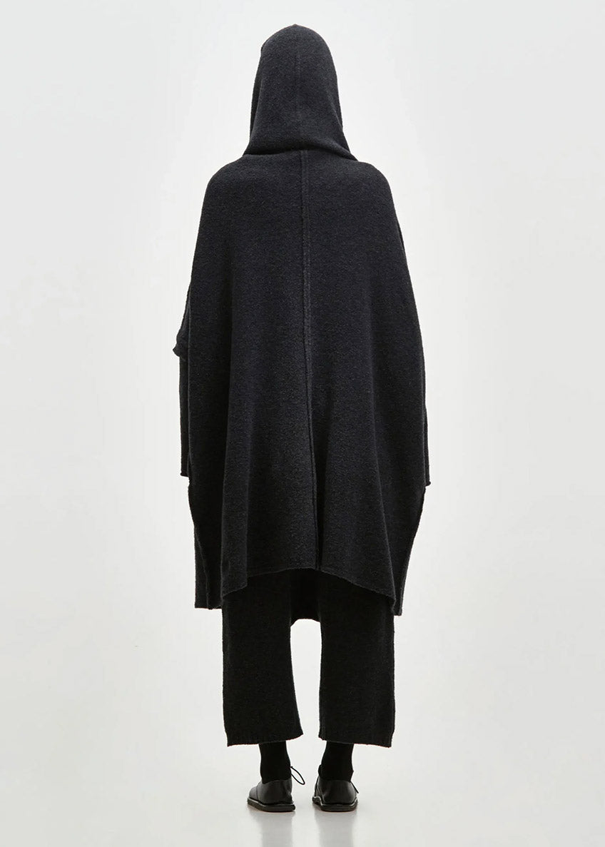 Person wearing a black cardigan on a white background