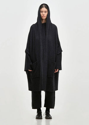 Person wearing a black cardigan on a white background