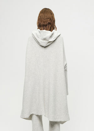 Person wearing a light gray hooded cardigan on a white background