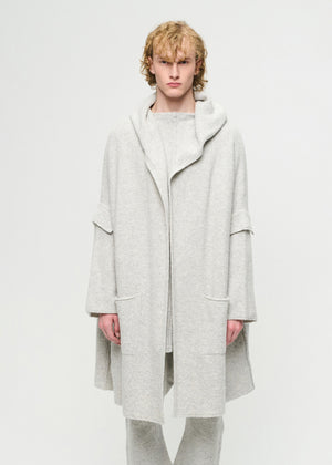 Person wearing a light grey cardigan on a white background