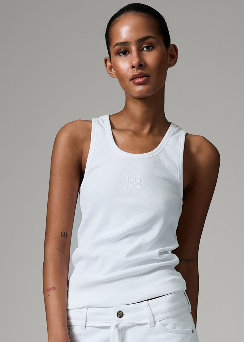 Woman wearing a white tank top with a logo on a gray background