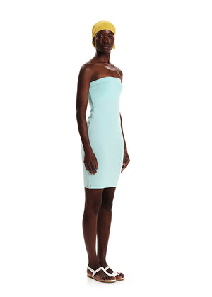 A woman wearing a turquoise strapless dress with a yellow headscarf.