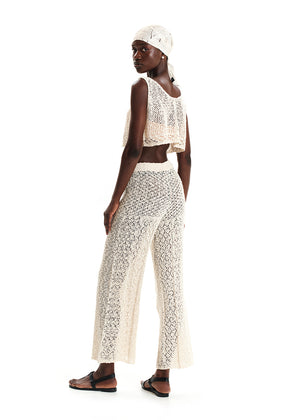 Woman wearing a white lace outfit on a white background