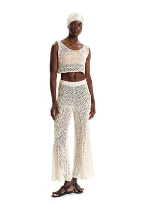 Woman wearing a white crochet outfit on a white background