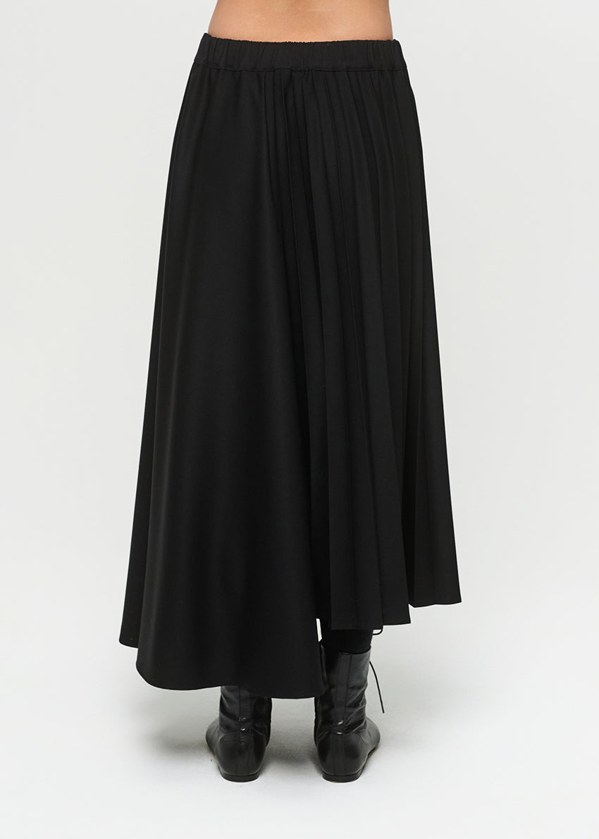 Black skirt worn by a person on a white background