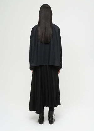 Person wearing a black coat and skirt set on a white background