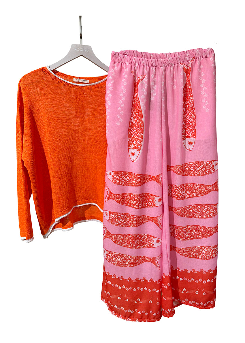 Orange long-sleeve shirt and pink pants with fish pattern on a white background