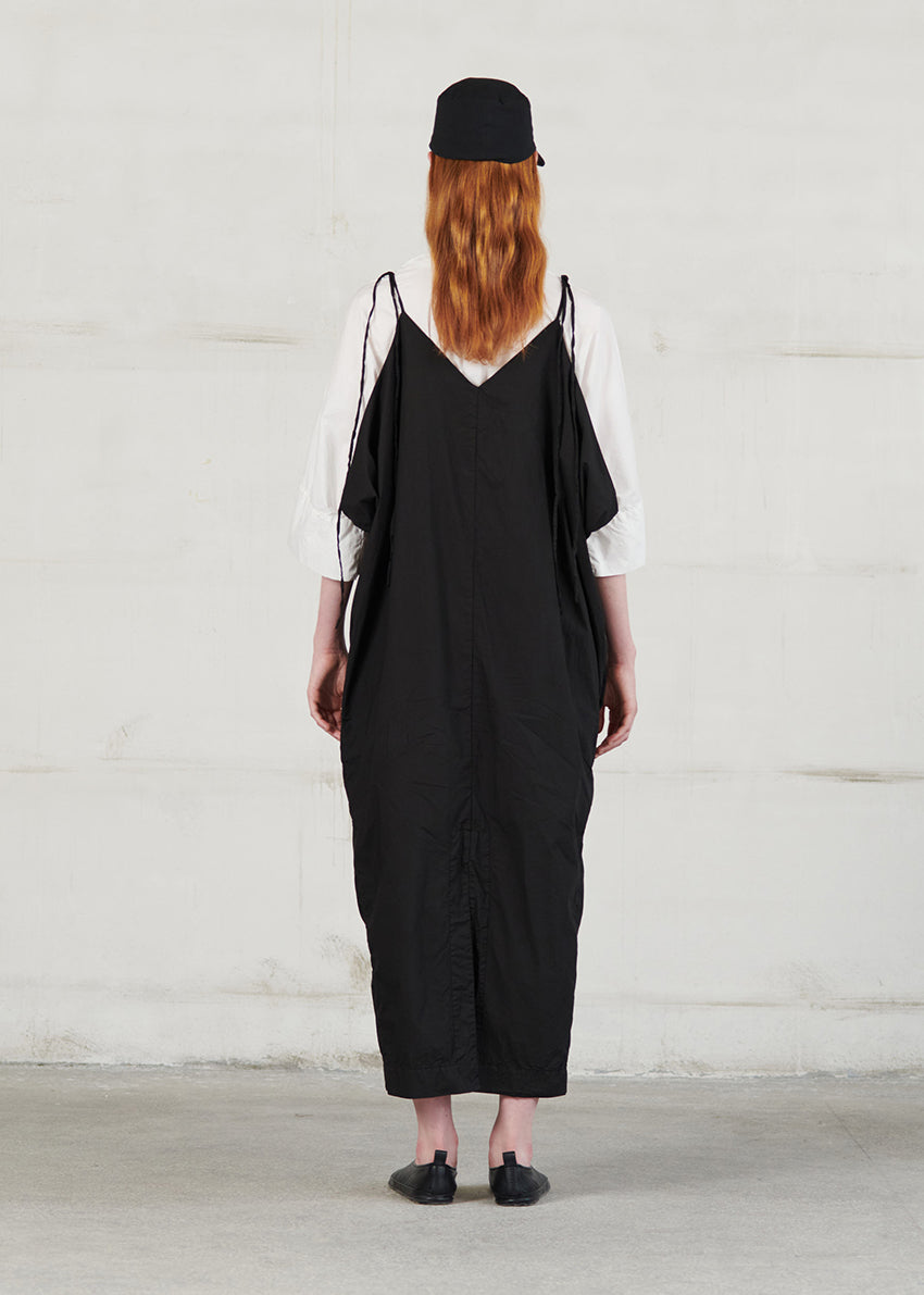 Long dress with thin straps, cut for a relaxed fit, made of soft cotton poplin. CASO features a V neck both in the front and back, open low armholes creating draping on the sides, and decorative nervirs on the front side.