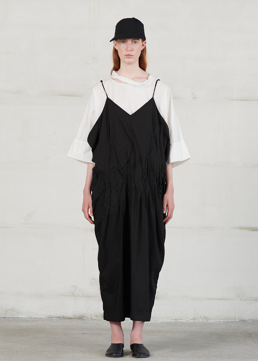 Long dress with thin straps, cut for a relaxed fit, made of soft cotton poplin. CASO features a V neck both in the front and back, open low armholes creating draping on the sides, and decorative nervirs on the front side.