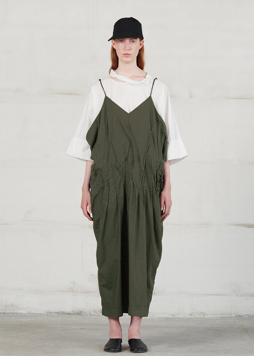 Long dress with thin straps, cut for a relaxed fit, made of soft cotton poplin. CASO features a V neck both in the front and back, open low armholes creating draping on the sides, and decorative nervirs on the front side.