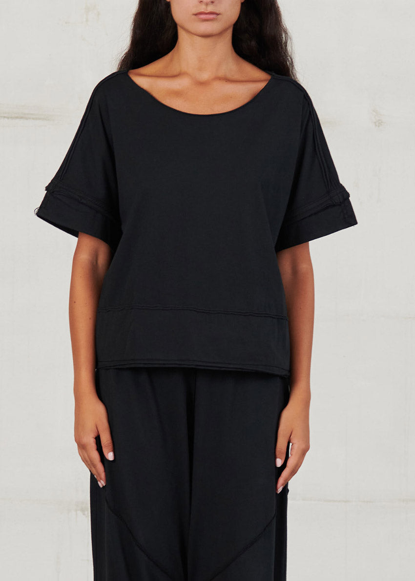 Person wearing a black outfit against a white background