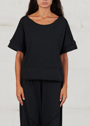 Person wearing a black outfit against a white background