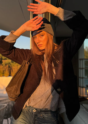 Woman adjusting a cap outdoors with blurred background