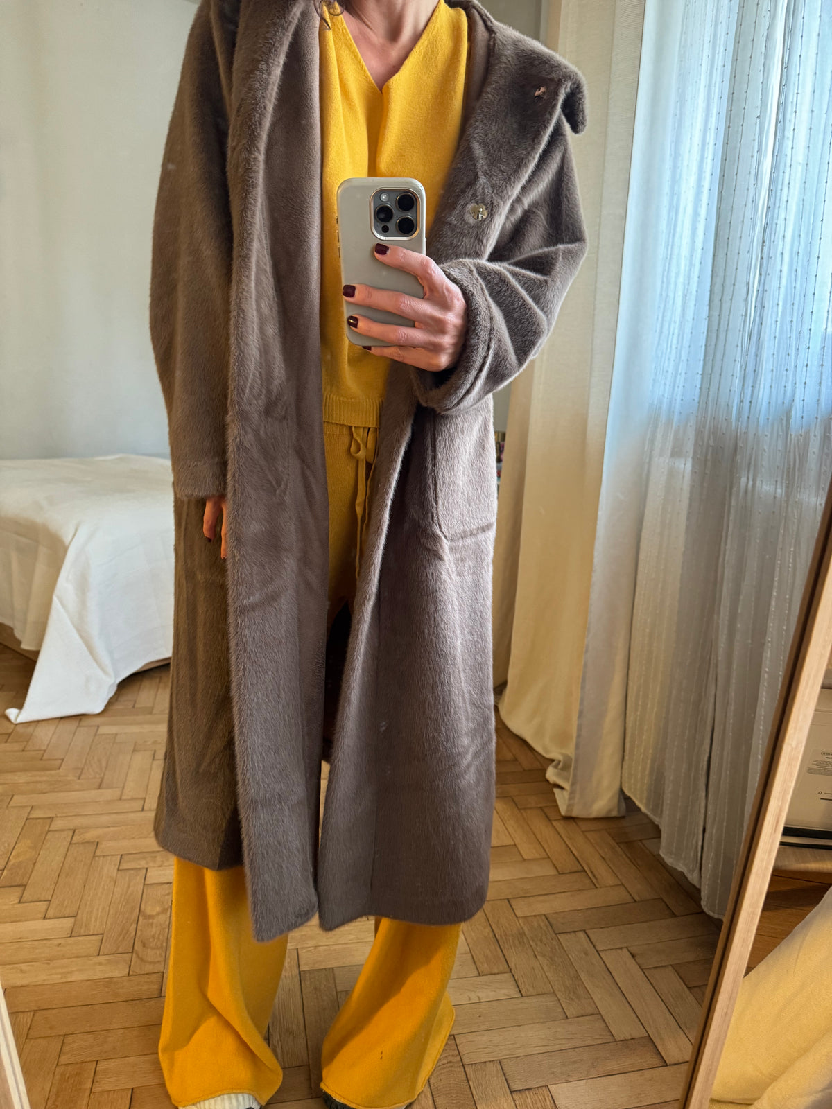 This ultra-fine faux-fur coat features a high density weave of fibres that are thinner than silk, providing a soft and fluffy texture. The coat is fully lined and includes a hoodie, plank frontal pockets, and metallic staples, all in a solid color. 