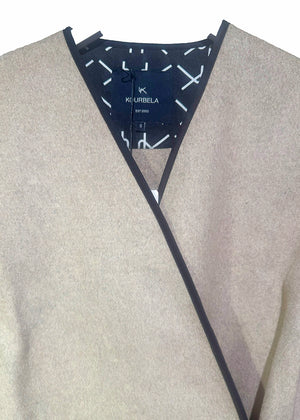 Short wrap beige coat made of furry wool that ties at the side and has a detachable scarf.A winter must – have coat that can be worn from morning to night.