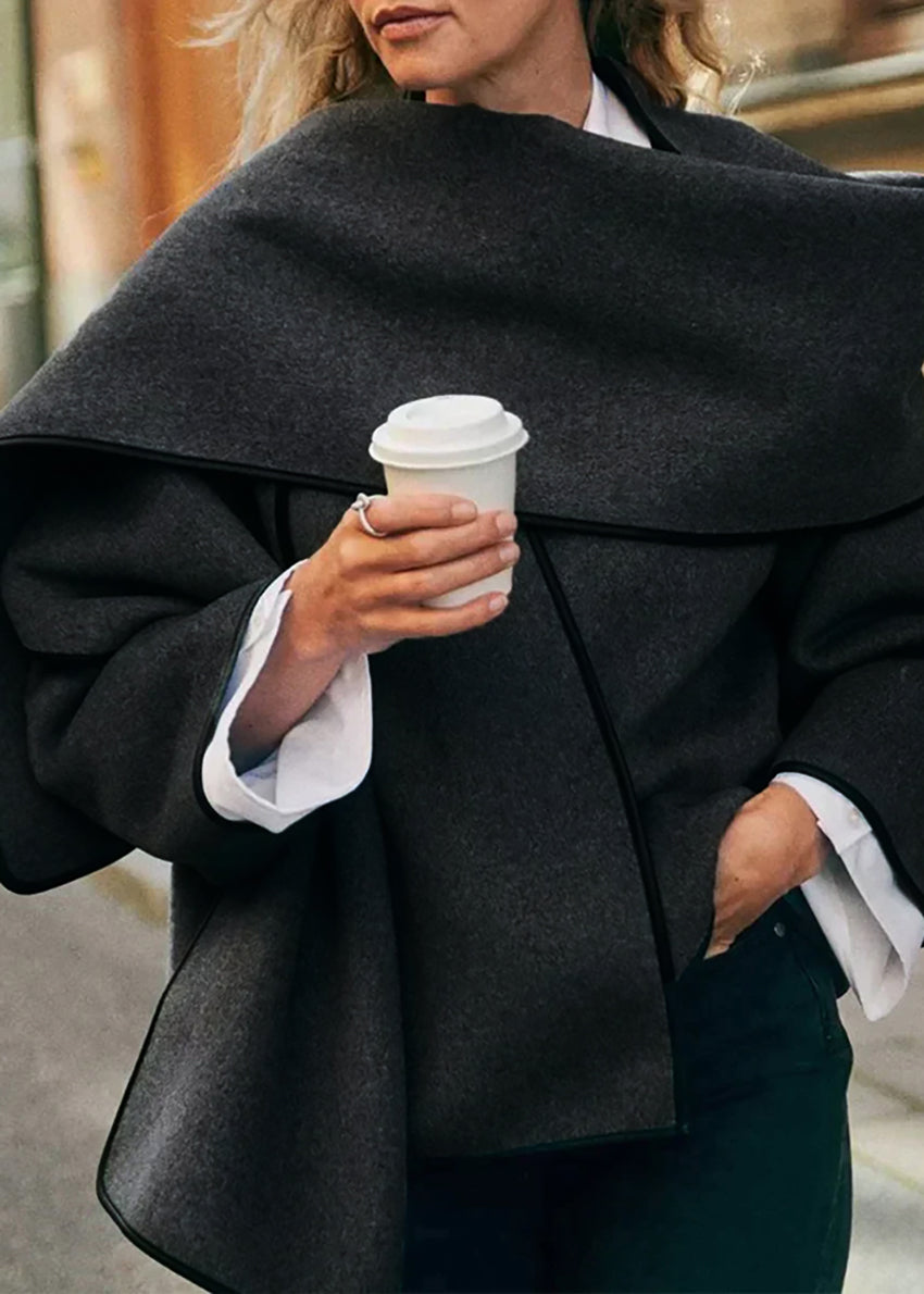 Short wrap black coat made of furry wool that ties at the side and has a detachable scarf.A winter must – have coat that can be worn from morning to night.