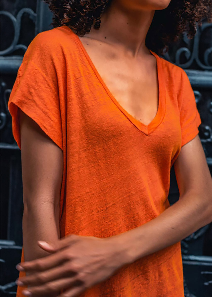 Person wearing an orange t-shirt with a blurred background