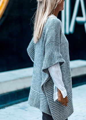 Side photo of a woman who wear a grey poncho