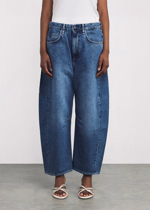 Person wearing blue jeans on a plain background