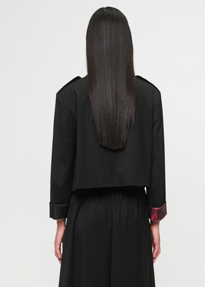Person wearing a black outfit with a plain background