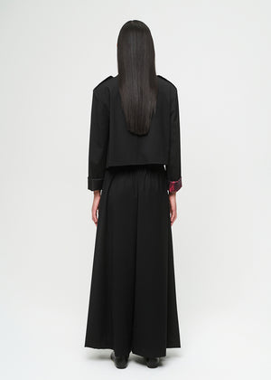 Person wearing a black outfit with a long skirt on a white background