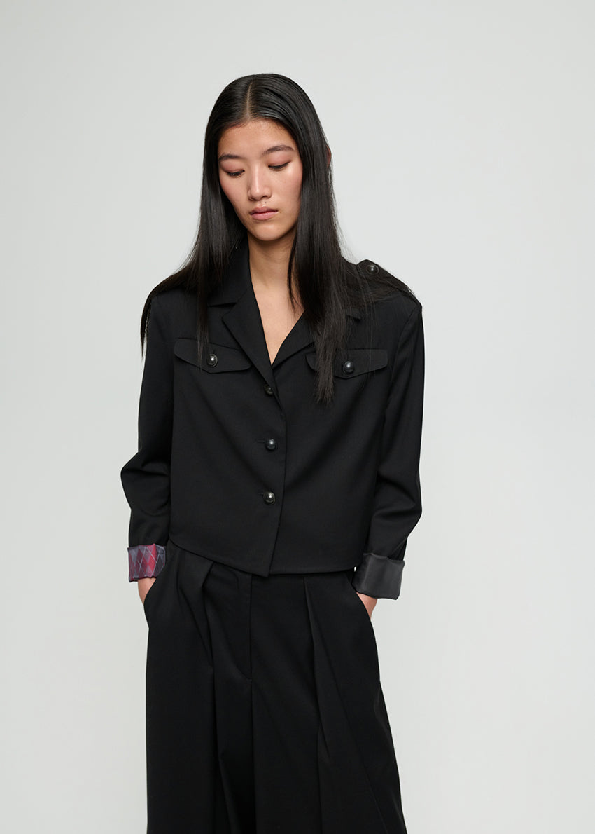 Woman wearing a black outfit with a plain background