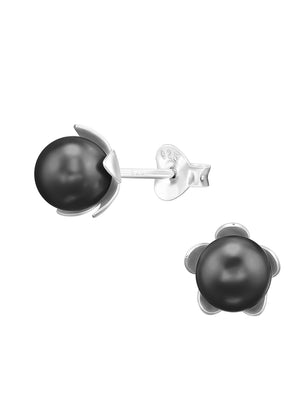 A pair of silver earrings with black-colored flower-shaped pearls, against a white background.