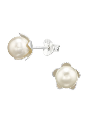 A pair of silver earrings with cream-colored flower-shaped pearls, against a white background.