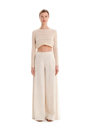 Person wearing a beige knit crop top with matching pants on a white background 