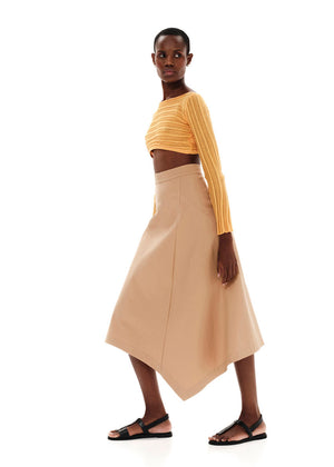 Person wearing a yellow knit crop top with a brown skirt on a white background 
