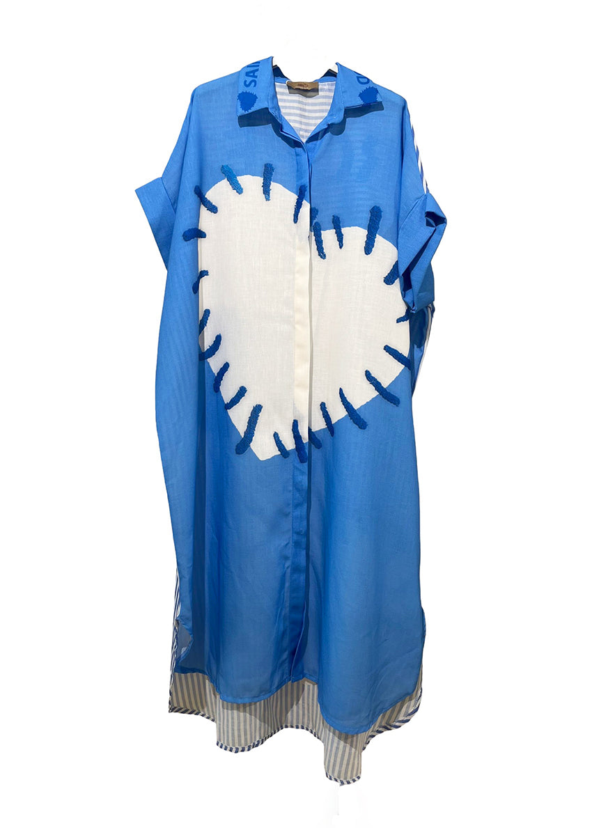 Woman wearing a blue and white patterned dress with a white background