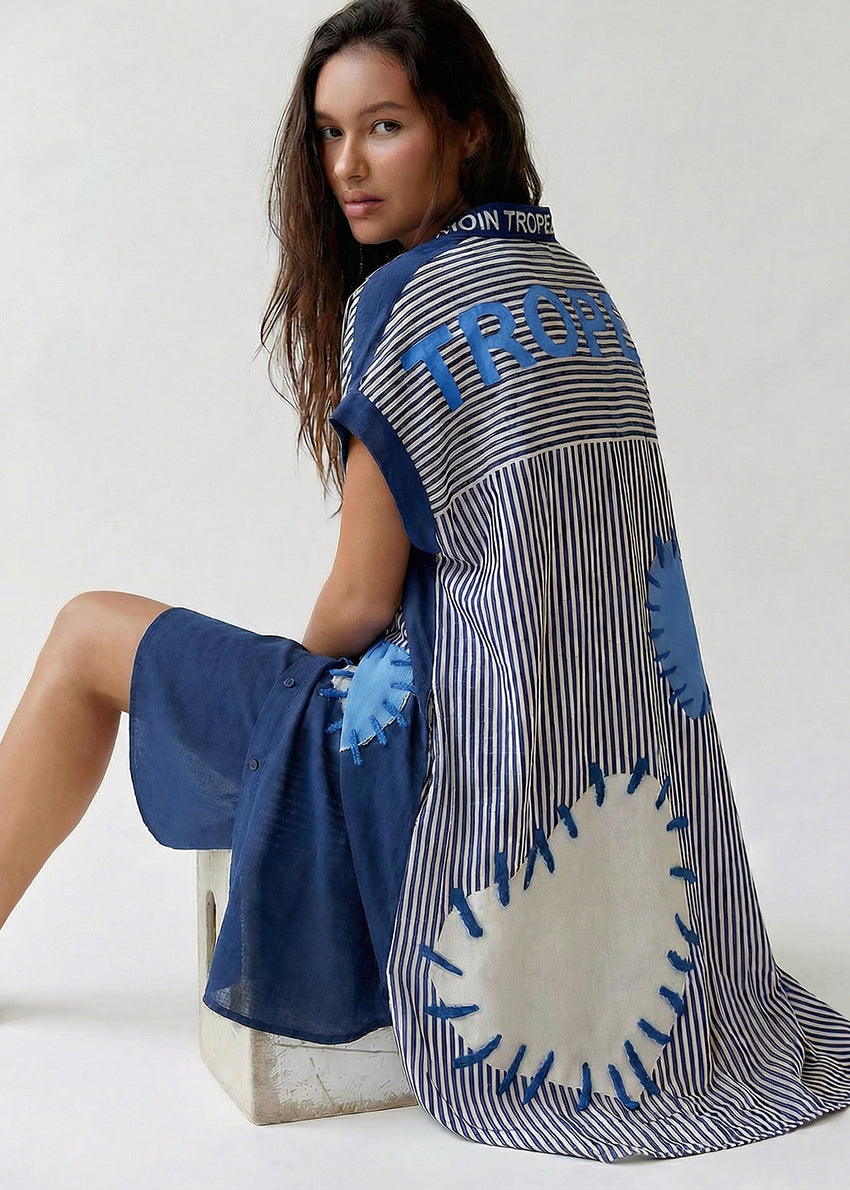 Woman wearing a blue and white patterned dress with a white background