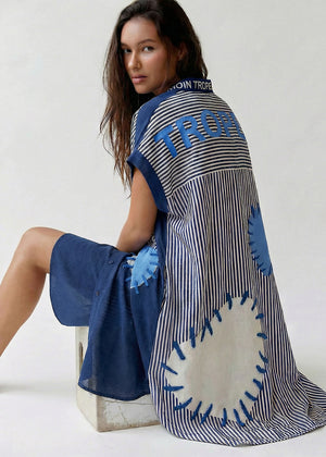 Woman wearing a blue and white patterned dress with a white background