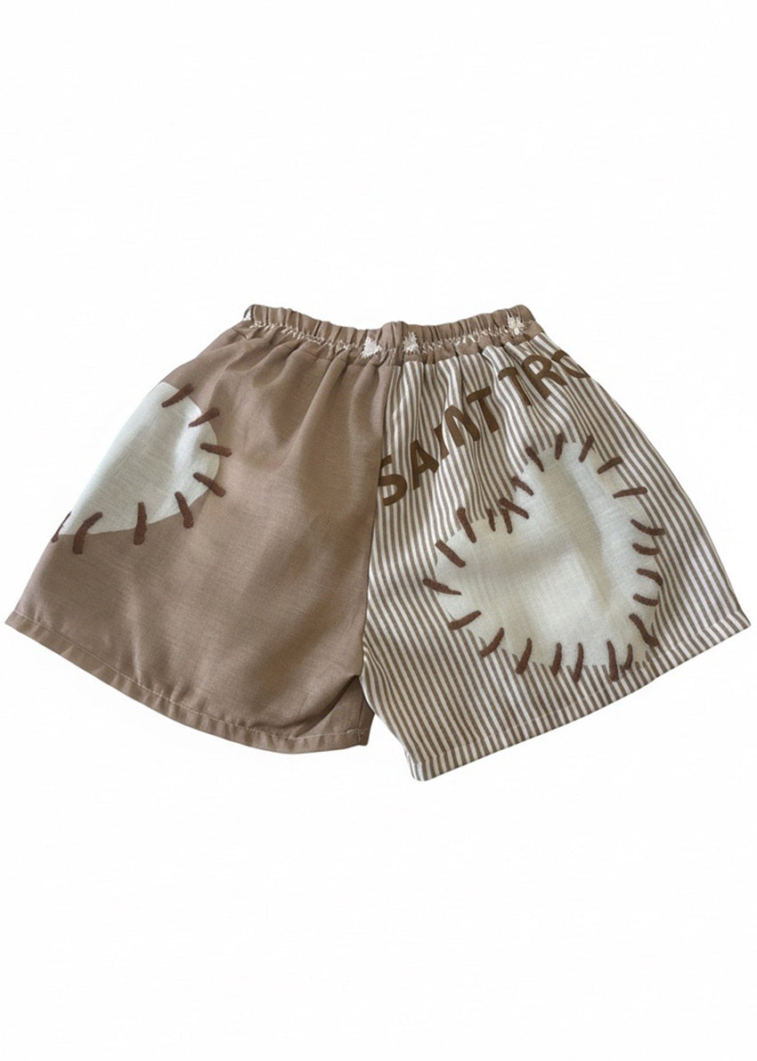 Short pants in a beige color with white stripes and white hearts on a white background 