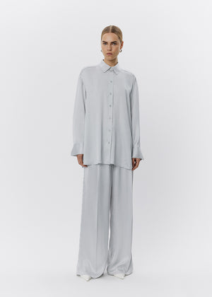 Person wearing a light gray outfit on a white background