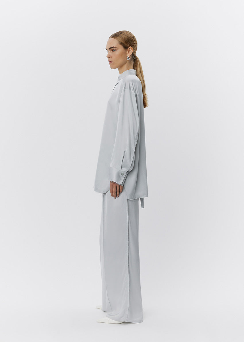 Woman wearing a light gray outfit on a white background