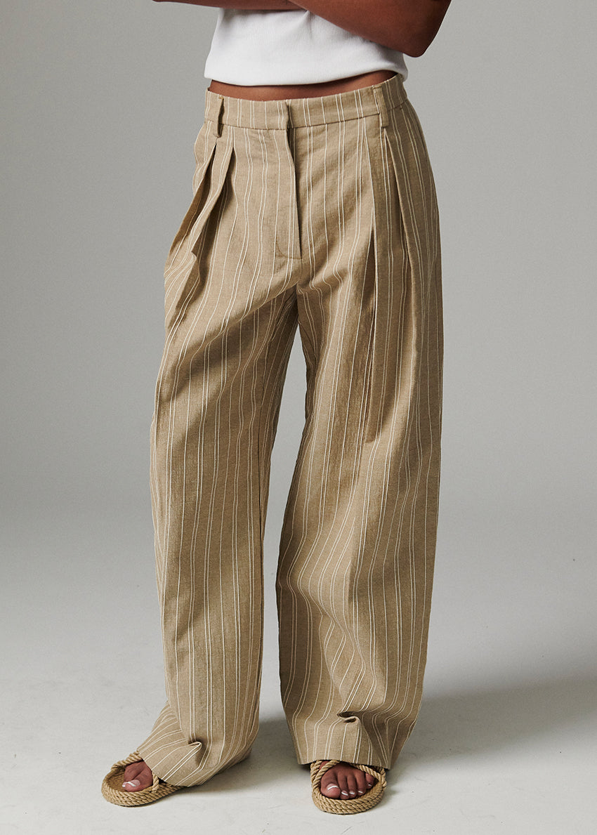 Beige striped pants worn by a person on a plain background