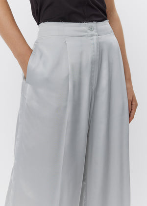 Light gray wide-leg pants worn by a person on a white background