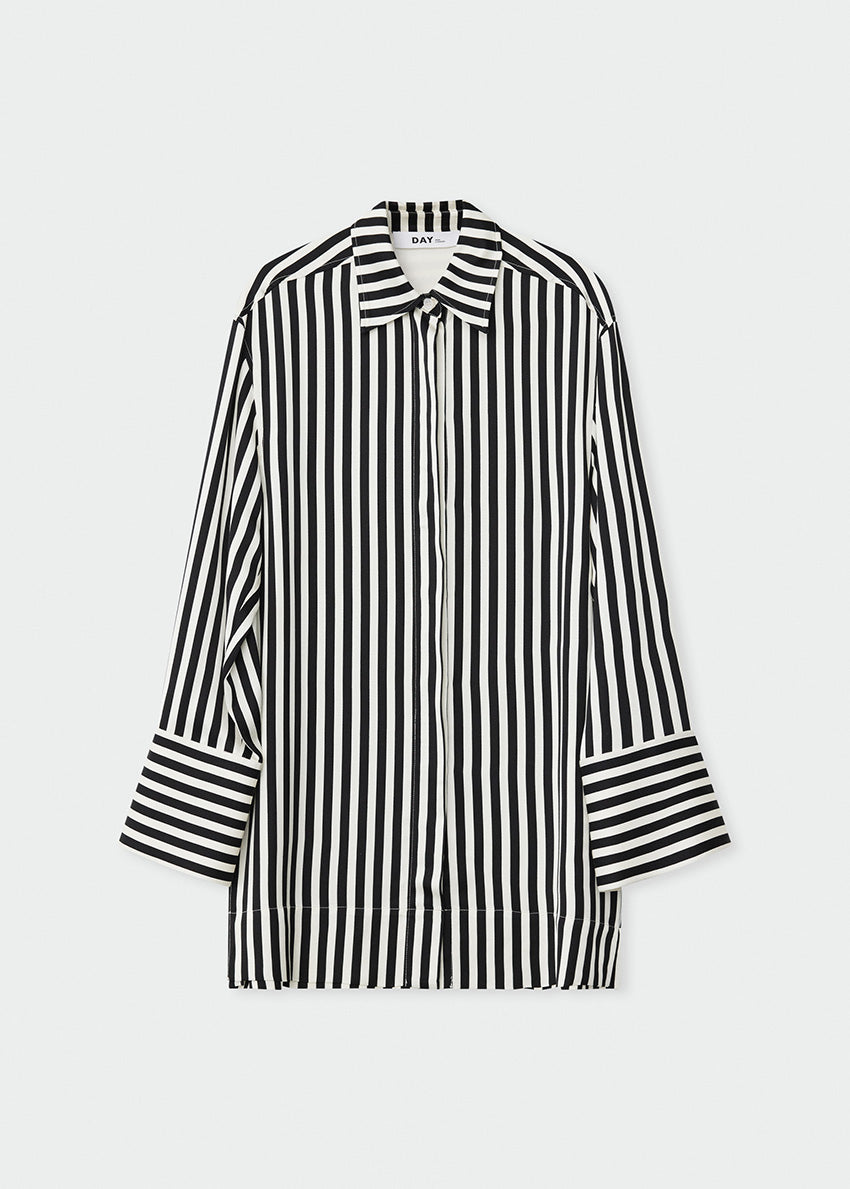 Woman wearing a black and white striped shirt against a plain background