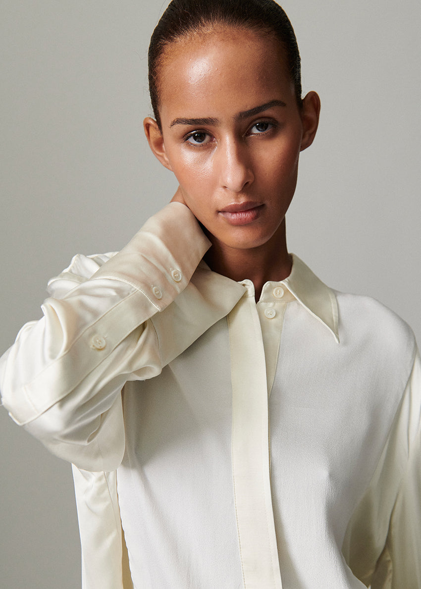 Woman wearing a white shirt against a plain background
