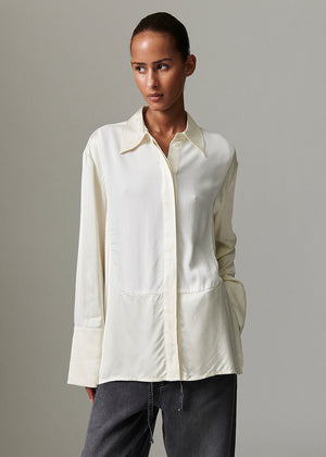 Woman wearing a white shirt against a gray background